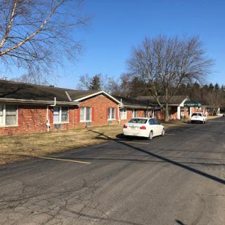 A quiet residential street lined with brick buildings under a clear blue sky.