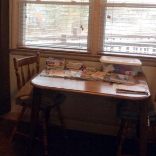 A small kitchen table with two chairs by a window, letting in natural light.