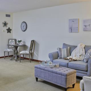 A cozy living room with a sofa, coffee table, and adjacent dining area.
