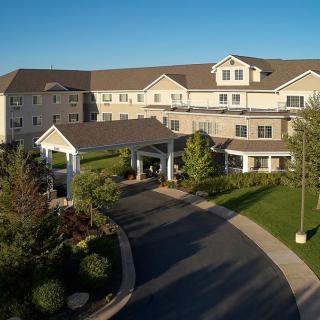 A well-maintained residential building with a landscaped entrance and driveway.
