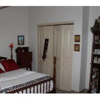 A cozy bedroom with classic furnishings and a neatly made bed.