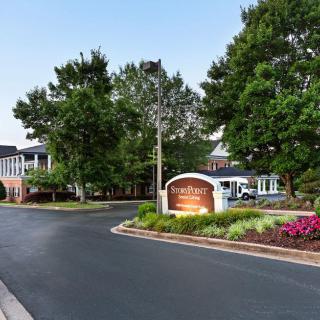 Entrance to a hotel with well-maintained landscaping and clear signage.