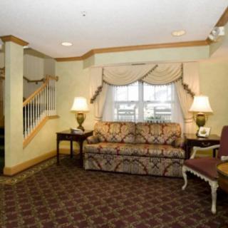 A traditionally designed living room with a patterned sofa, lamps, and carpet.