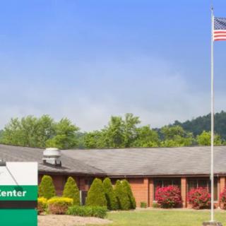 A health center building with an American flag and surrounded by greenery.