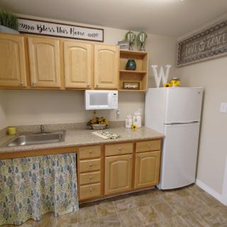 A cozy kitchen with wooden cabinets, a fridge, and decorative elements.