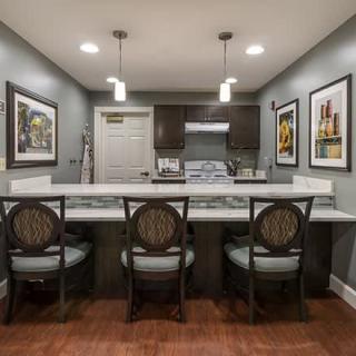 Modern kitchen with a marble countertop, bar stools, and pendant lighting.