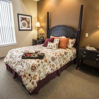Cozy bedroom with decorative pillows and warm lighting.