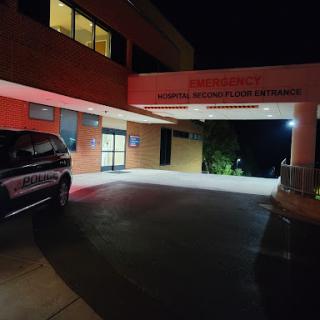 The illuminated entrance of a hospital at night.