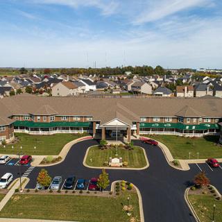 Aerial view of a large building with a parking lot in a suburban area.