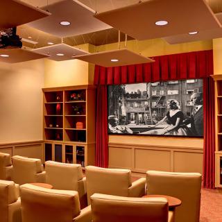 A cozy home theater with comfortable seating and a large screen for movie viewing.
