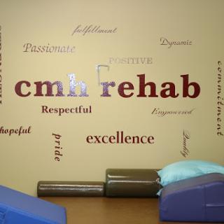A wall in a rehabilitation center displaying motivational words and the center's name.