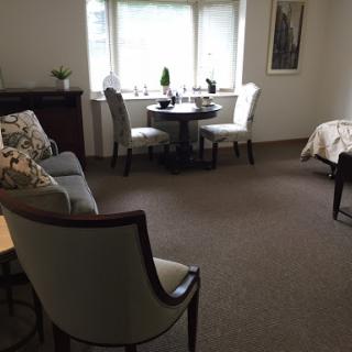 A cozy living space featuring comfortable seating, a small dining table by the window, and tasteful decor.