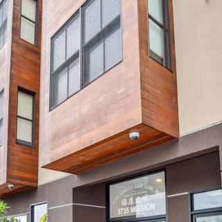 A modern urban building with wooden accents and large windows.