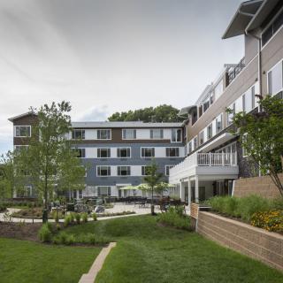 A modern residential building with well-maintained landscaping and a garden pathway.