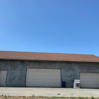 A large building with multiple garage doors under a clear blue sky.
