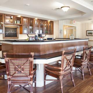 A stylish bar area with wooden chairs and a polished counter.