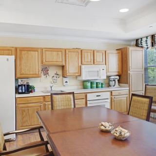 A bright kitchen with wooden cabinets and a connected dining area.