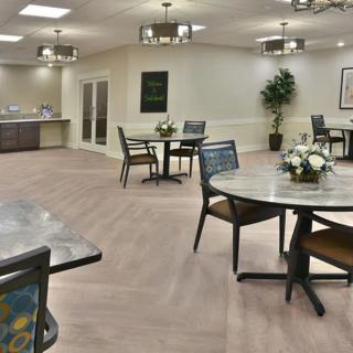 A modern dining area with round tables, chairs, and decorative elements.