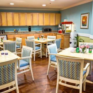 A cozy dining and kitchen area with tables, chairs, and a popcorn machine.