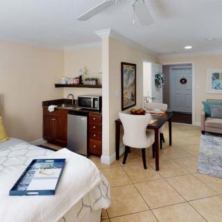 A cozy studio apartment featuring a comfortable bed, a small kitchenette, and a dining area.