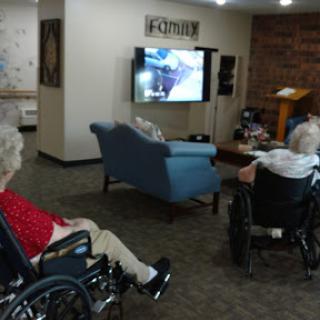 Residents enjoying a moment in the common area while watching television.