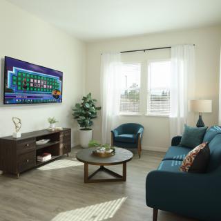 A modern living room with stylish furniture and a television on the wall.
