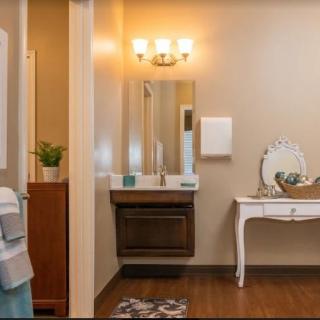 A cozy bathroom with a well-lit vanity area and elegant decor.