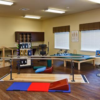 A well-equipped physical therapy room featuring various exercise tools and mats for rehabilitation purposes.