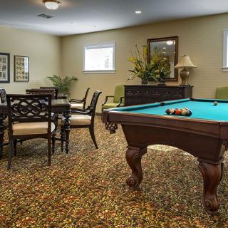 A cozy game room featuring a billiards table and a dining area.