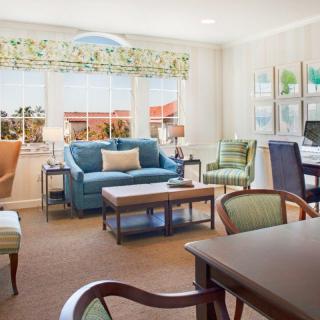 A cozy and well-decorated living room with various seating options and natural light from the windows.