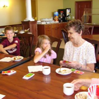 A family enjoying a card game together at a table indoors.