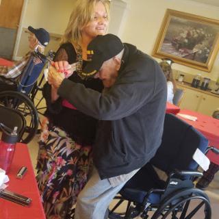 A warm moment of connection between a caregiver and a resident in a care facility.