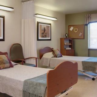 A shared hospital room with two beds and simple decor.