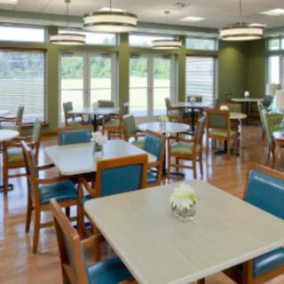 A modern and empty dining area with neatly arranged tables and chairs.