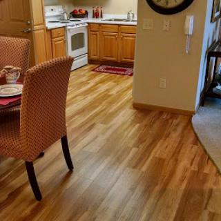 A cozy kitchen and dining area featuring wooden flooring and modern appliances.