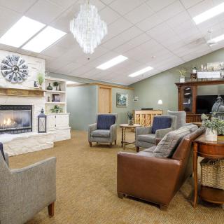 A cozy living room featuring comfortable seating and a fireplace with modern decor.