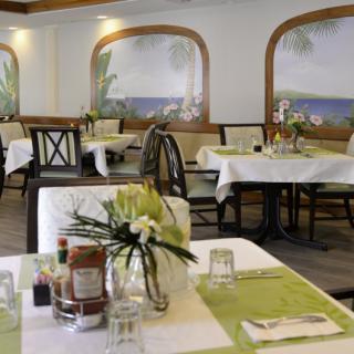 A cozy restaurant dining area with neatly set tables and floral decorations.