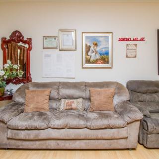 A cozy living room with a plush sofa, artwork, and decorative elements on the wall.