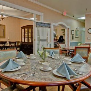 A well-set dining table with blue napkins in a cozy restaurant interior.