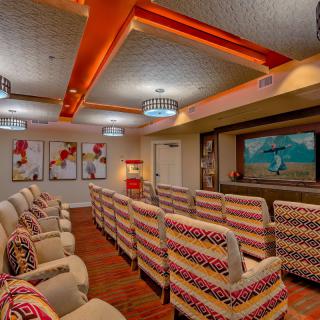 A cozy home theater with colorful seating and vibrant artwork.