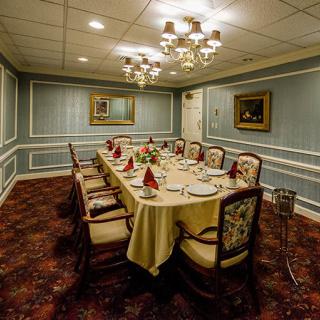 A formal dining room with an elegantly set table and chandelier lighting.