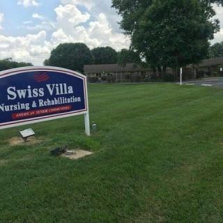 Swiss Villa Nursing & Rehabilitation sign on a grassy lawn with building in the background.
