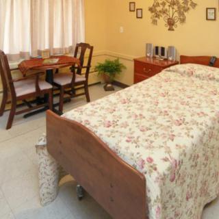 A cozy bedroom with floral bedding and wooden furniture.