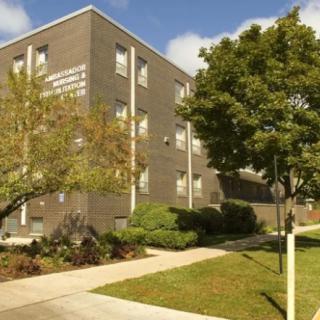 A college building with a landscaped exterior and a pathway on campus.