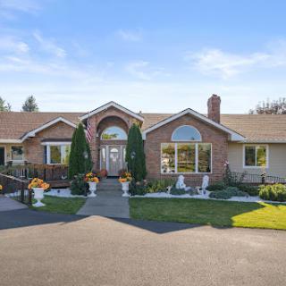 A beautiful brick house with well-maintained landscaping under a clear blue sky.