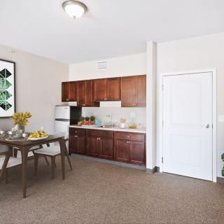 A cozy kitchen and dining area with wooden cabinets and a small dining table set.