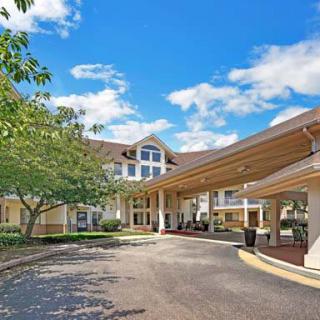 A welcoming building entrance with a driveway and a clear blue sky overhead.