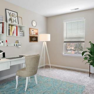 A cozy and well-organized home office space with a desk, chair, bookshelves, and a floor lamp.