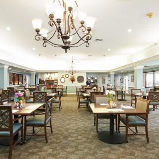 Spacious dining area with elegant chandeliers and neatly arranged tables.