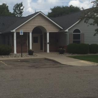 A small suburban building with a front entrance and driveway.